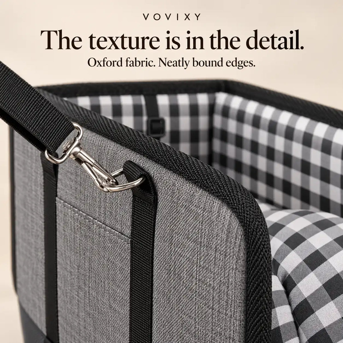 Close-up of the grey Oxford fabric exterior, black edge binding and metal strap clip