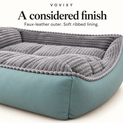 Close-up of seafoam faux-leather outer panels and grey ribbed velvet on the dog sofa bed