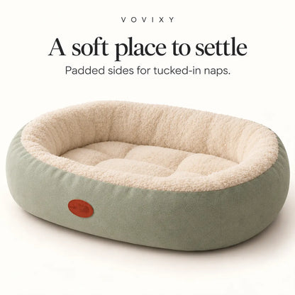 Sage Green oval bolster pet bed with raised sides and a cream quilted sleeping area